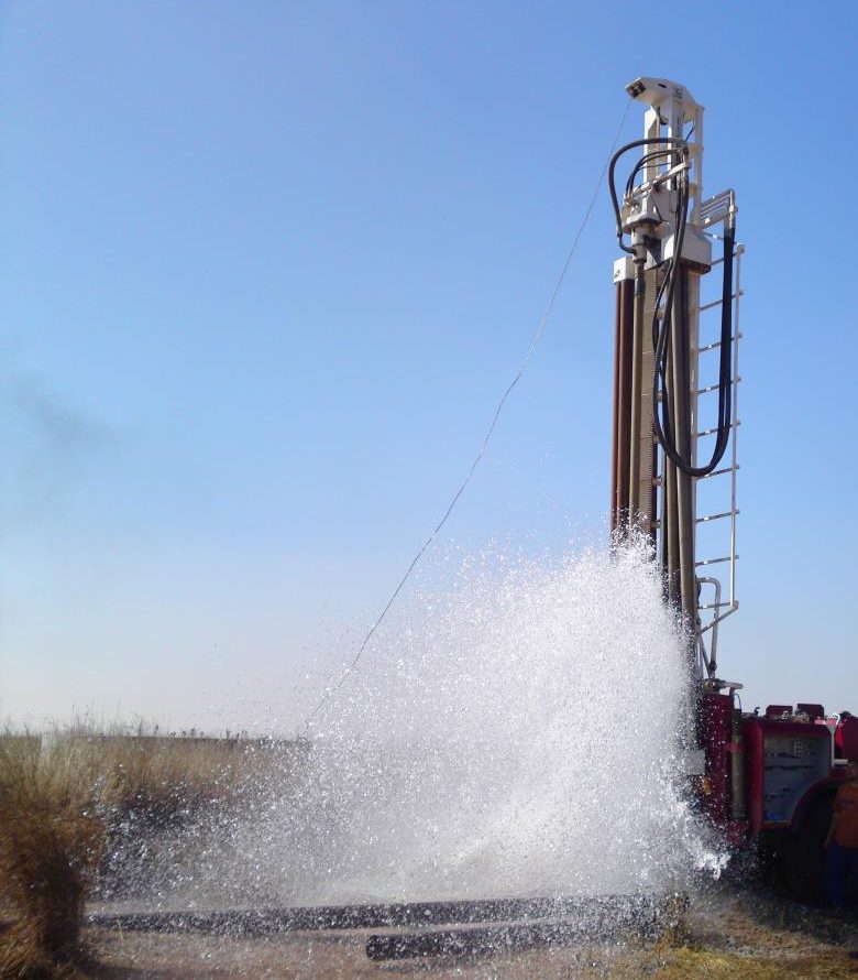 Rotary drilling rig striking water while drilling a new water well